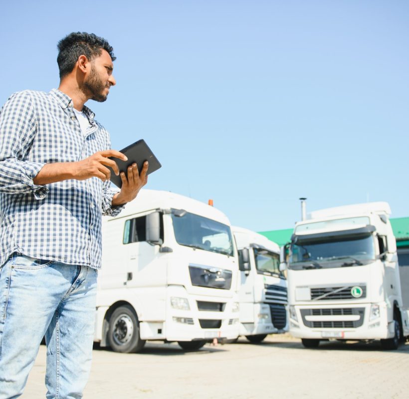 Young indian man standing by his truck. The concept of freight transportation
