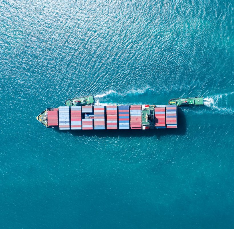 Cargo container Ship with Tug Boat, cargo maritime ship with contrail in the ocean ship carrying container and running for export concept technology freight shipping sea freight by Express Ship. top view