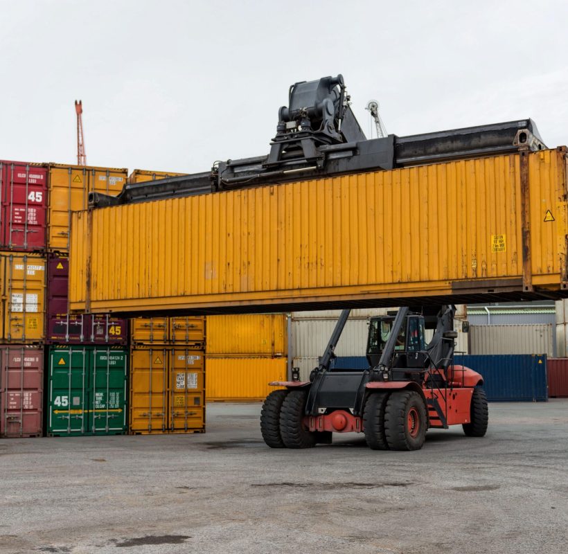 Mobile stacker handler in action at a container terminal.